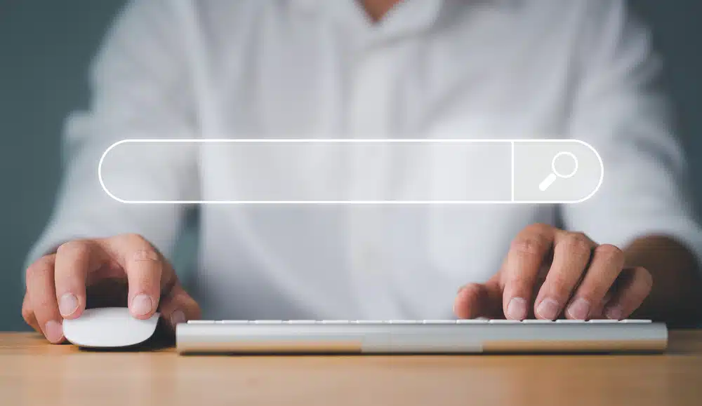 Person typing at a keyboard with a digital search bar overlay representing a Companies House director search