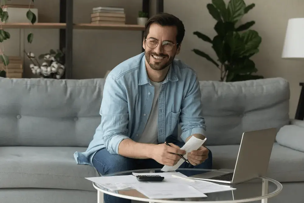 A man reviewing documents and receipts at home while researching the cost of company formation in the UK