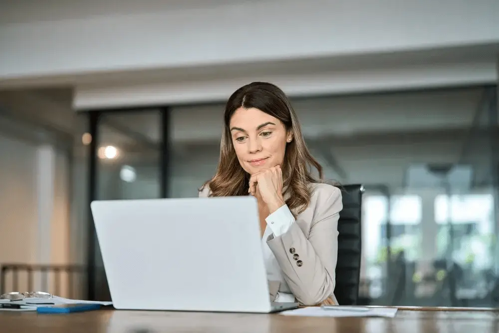 Businesswoman reviewing company formation documents on a laptop at her office desk