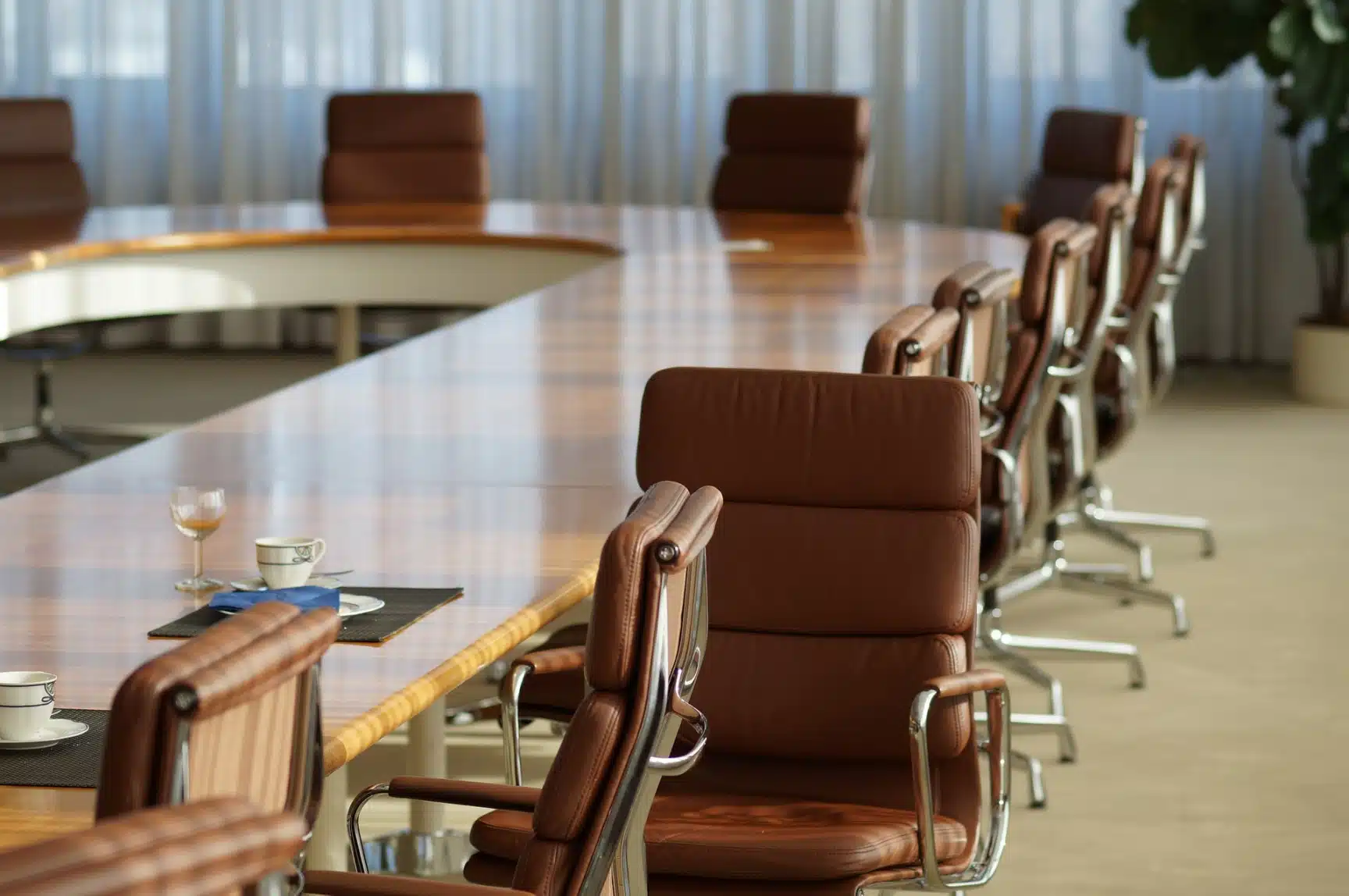 Empty boardroom with office chairs and table setting illustrating How to Close or Dissolve a Company concept