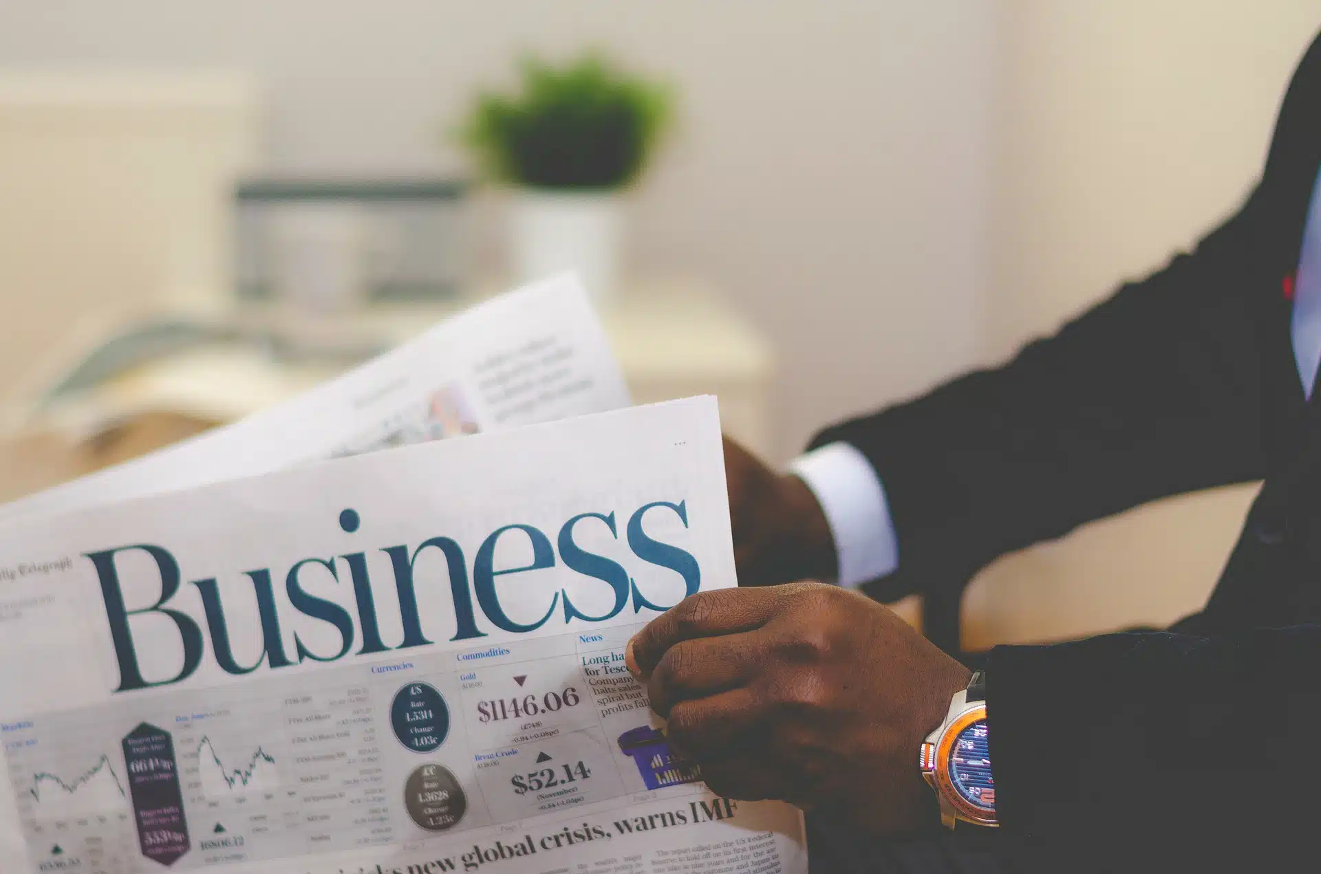 Person in suit holding Business newspaper with charts in How To Set Up Best Practice Guidelines for your Company article