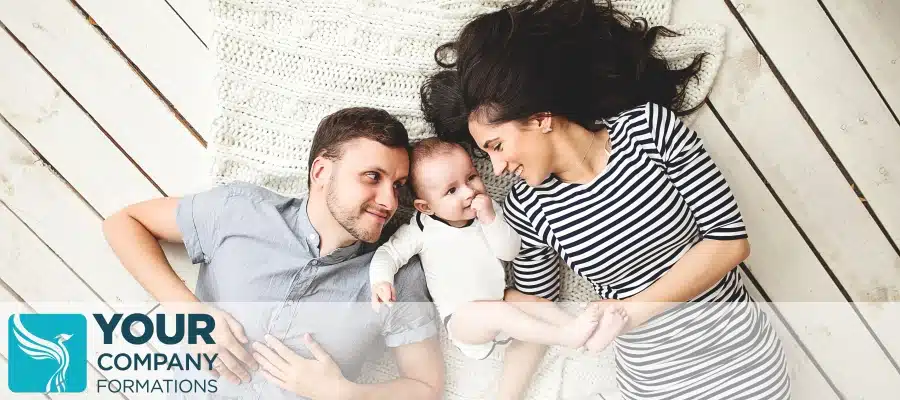 Parents lying with baby on blanket at home, illustrating Maternity Pay and Benefits for Company Directors family life