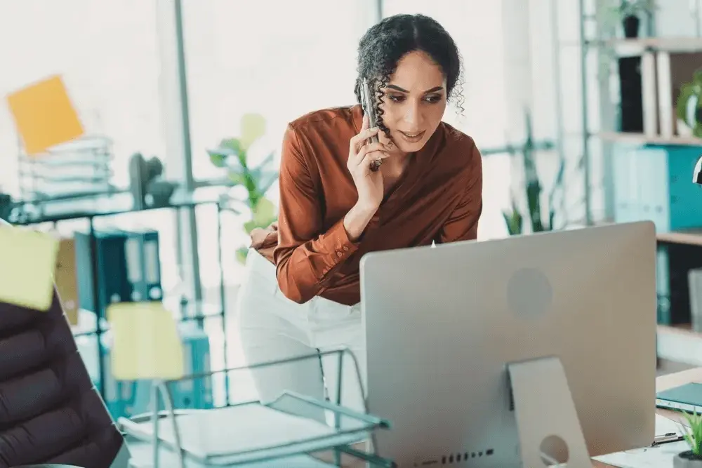 A businesswoman on the phone at her office desk arranging to set up a limited company with tax and accounting support