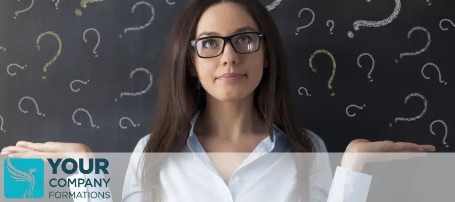 Woman with glasses shrugging before chalkboard with drawn question marks illustrating prescribed particulars article