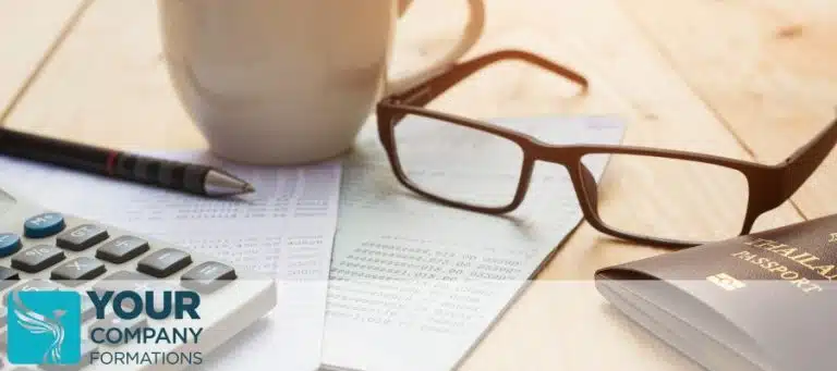 Glasses, calculator, pen, and cup of coffee on top of documents for company annual accounts article